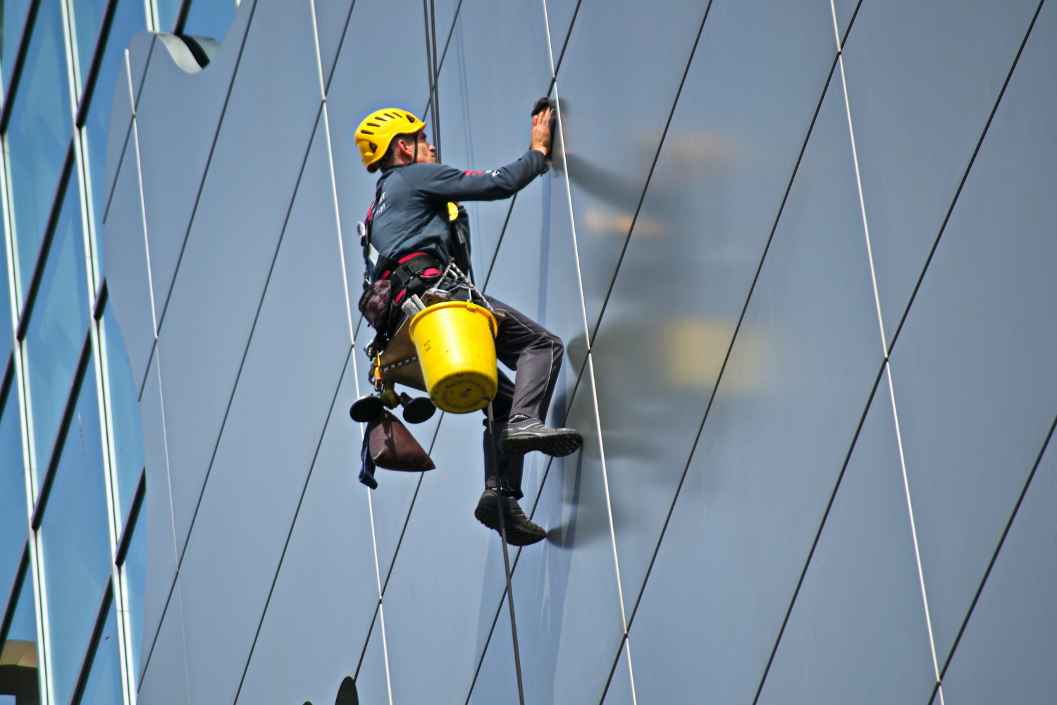 Man Cleaning the Glass of Building
